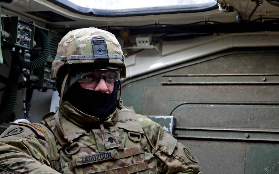 Spc. John Zagozdon of Iron Troop, 3rd Squadron, 2nd Cavalry Regiment talks about training in Estonia and the convoy from there back to Vilseck, Germany, during a fuel stop in Lithuania, Monday, March 23, 2015.