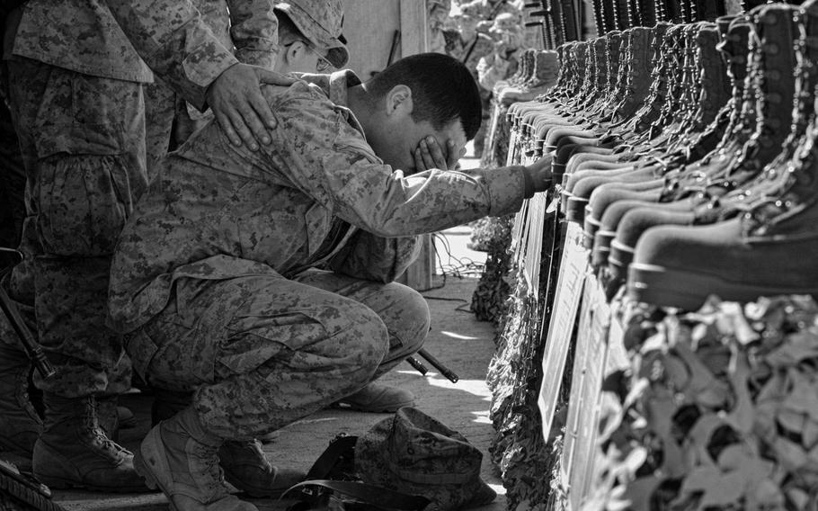 A U.S. Marine is lost in tears during the memorial service for 31 servicemembers killed at Camp Korean Village, near Ar Rutbah, western Iraq, on Feb. 2, 2005. Thirty Marines and one sailor died on Jan. 26, 2005, when their helicopter crashed near Rutbah while conducting security operations.