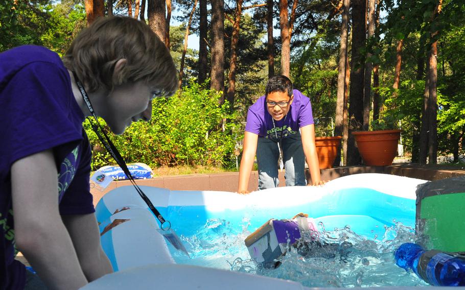 Ronan Stackpole, left, and Elijah Tross, students at Wiesbaden Middle School, shake the sides of an inflatable pool to test the buoyancy of their handmade houseboats on Thursday, May 14, 2015, during the second annual middle school STEMposium at Ramstein Air Base, Germany. Fifty-four students from the DODDS-Europe Kaiserslautern District participated in the two-day event.