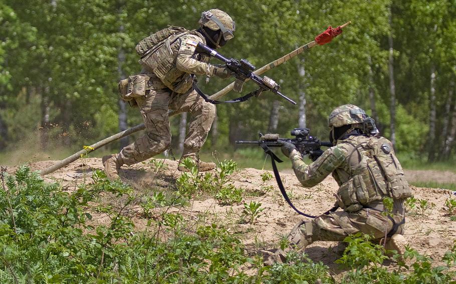 U.S. Spc. Edgar Pinpena, left, sprints back to his base with the opposing team's flag while Spc. Jesse Bray, covers his retreat during a force-on-force competition with Team Eagle's Lithuanian partners at the Great Lithuanian Hetman Jonusas Radvila Training Regiment, in Rukla, Lithuania, May 28, 2015. The soldiers of Team Eagle are part of Operation Atlantic Resolve, an ongoing multinational partnership focused on joint training and security cooperation between the U.S. and other NATO allies.