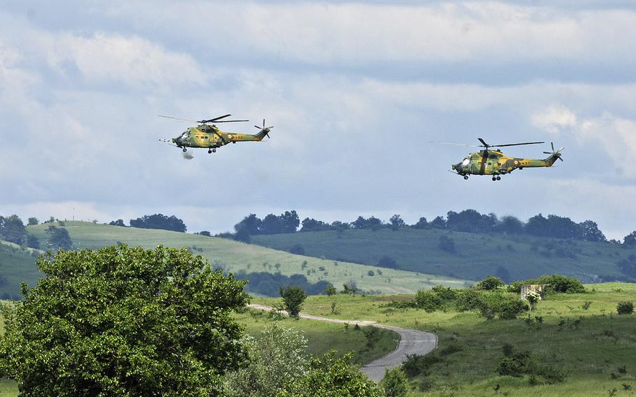 A pair of Romanian IAR-330 Puma helicopters fire missiles while conducting a dual helicopter attack during the aerial maneuver portion of the Distinguished Visitors Day demonstration at Cincu Training Area, Romania, May 26, 2015. This event featured demonstrations from several countries as part of Operation Atlantic Resolve-South.