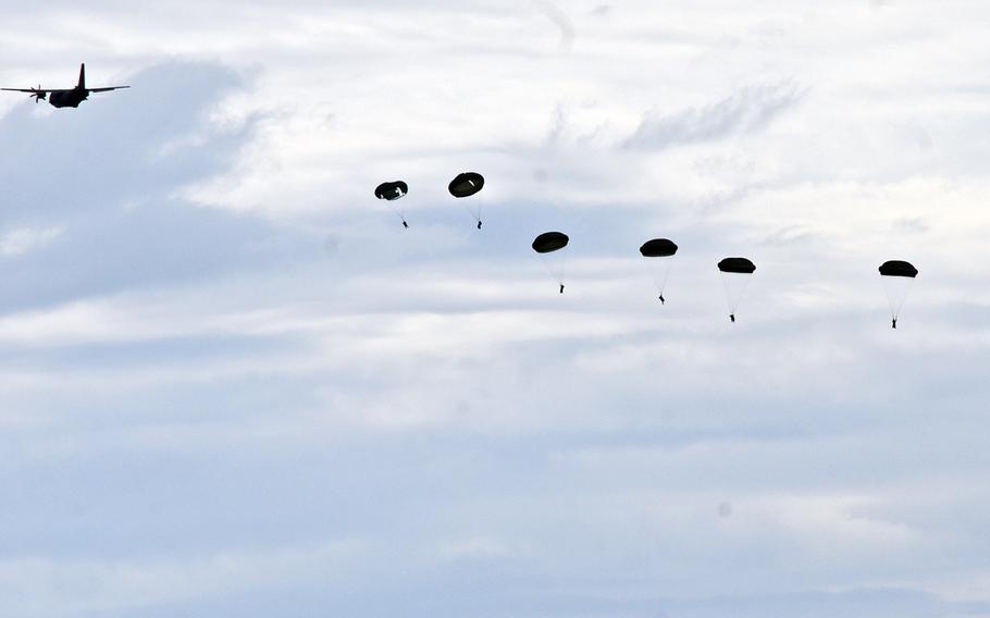 Airborne soldiers belonging to the Romanian land forces parachute into a landing zone during the mission readiness capabilities portion of the Distinguished Visitors Day demonstration at Cincu Training Area, Romania, May 26, 2015.