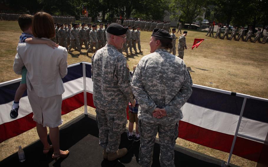 Col. Janell E. Eickhoff, right, and Col. Gregory Brady, second from right, talk as troops pass by following Eickhoff's assumption of command of the 10th Army Air and Missile Defense Command during a change of command ceremony for the unit Friday, June 12, 2015, at Daenner Kaserne in Kaiserslautern, Germany. Eickhoff and Brady served together as lieutenants in their first assignment in the Army in the 10th AAMDC's 5th Battalion, 7th Air Defense Artillery Regiment.