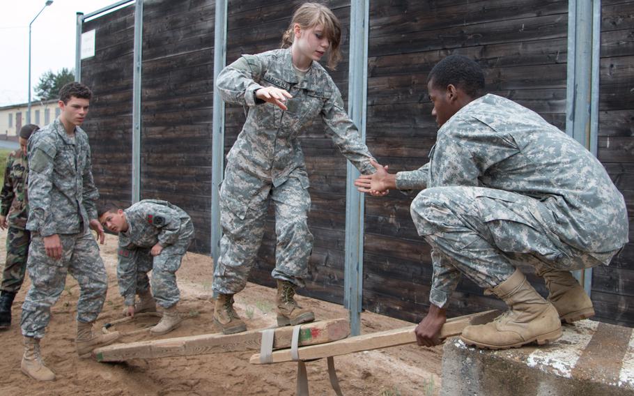 Junior ROTC cadets from Charlie Company 2 tackle a teamwork-building exercise while at the leadership reaction course at U.S. Army Garrison Grafenwoehr, Germany, on June 18, 2015.