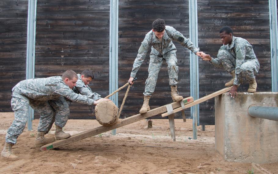Junior ROTC cadets come up with a creative solution to an obstacle presented to them at the leadership-reaction course held at Grafenwoehr, Germany.
