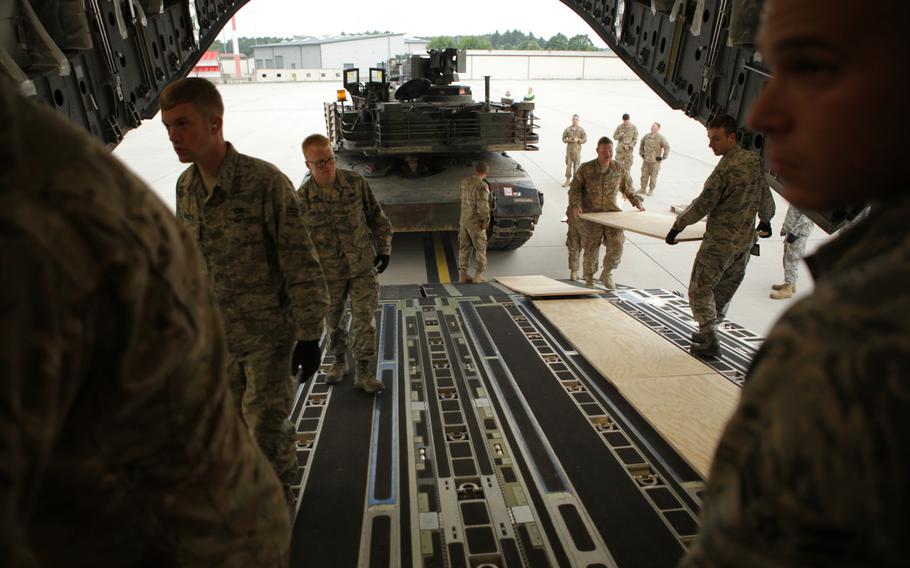 Soldiers and airmen prepare to load an M1A2 Abrams tank onto a C-17 transport plane at Ramstein Air Base in Germany on Saturday, June 20, 2015. The tank is one of two headed to Bulgaria for a live-fire exercise next week.
