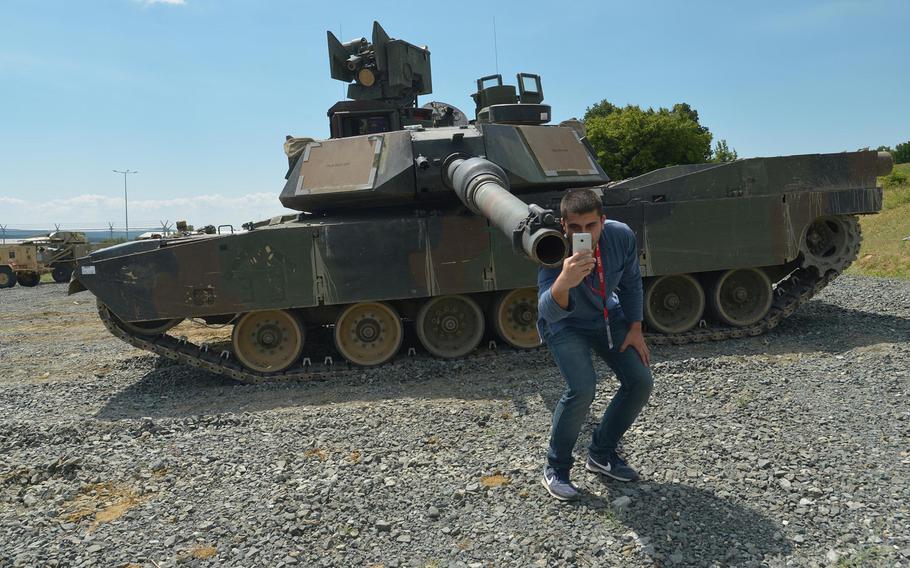 A local employee at the Novo Selo Training Area, Bulgaria, takes a selfie in front of an M1A2 Abrams tank, Wednesday, June 25, 2015. Two U.S. Army tanks manned by soldiers of the 3rd Infantry Division's 3rd Combined Arms Battalion, 69th Armored Regiment, out of Fort Stewart, Ga. are taking part in Thursday's live-fire demonstration at the training area.