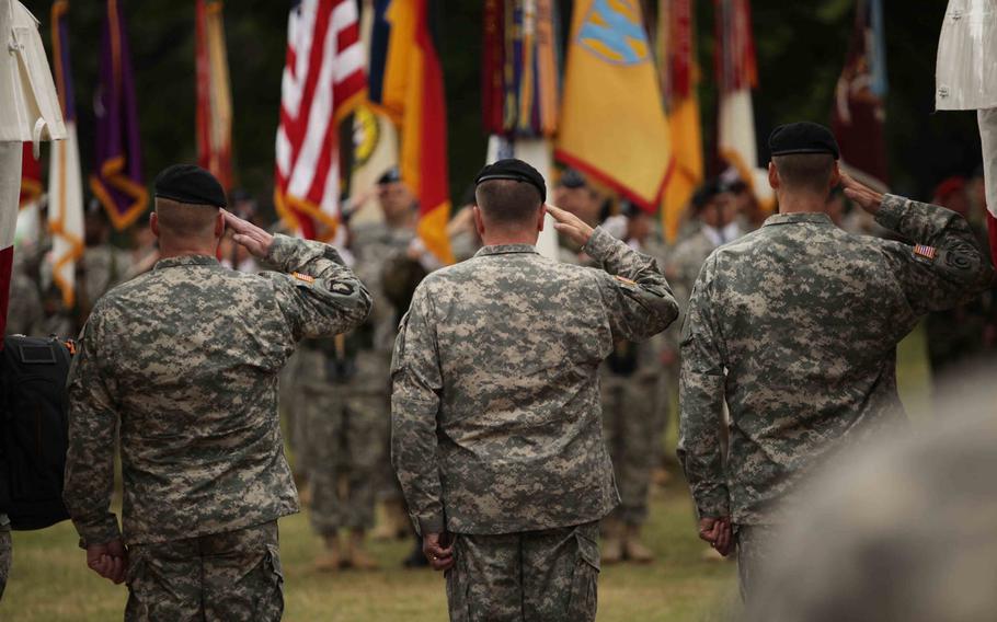 Maj. Gen. Duane A. Gamble the incoming commander of the 21st Theater Sustainment Command, U.S. Army Europe commander Lt. Gen. Ben Hodges, and outgoing 21st commander Maj. Gen. John R. O'Connor, salute the American flag during the playing of the national anthem at the TSC's change of command ceremony Wednesday, June 24, 2015, in Kaiserslautern, Germany.