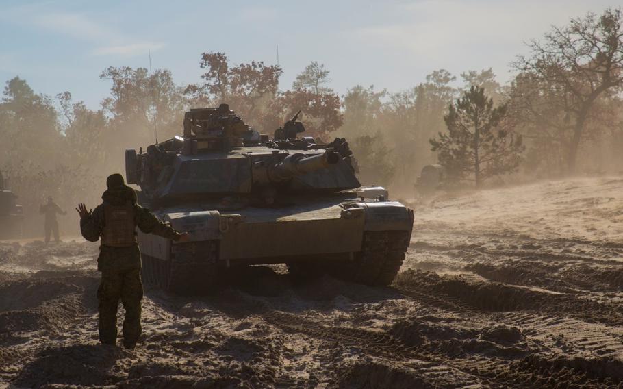 Cpl. Jose Peralta, a Marine with Company B, 2nd Tank Battalion, 2nd Marine Division, II Marine Expeditionary Force, guides a tank into a lane after conducting breaching exercises aboard Marine Corps Base Camp Lejeune, N.C, on Dec. 8, 2014. Marines with the II MEF will help form the Combined Arms Company, which will train with Bulgarian forces starting in September.