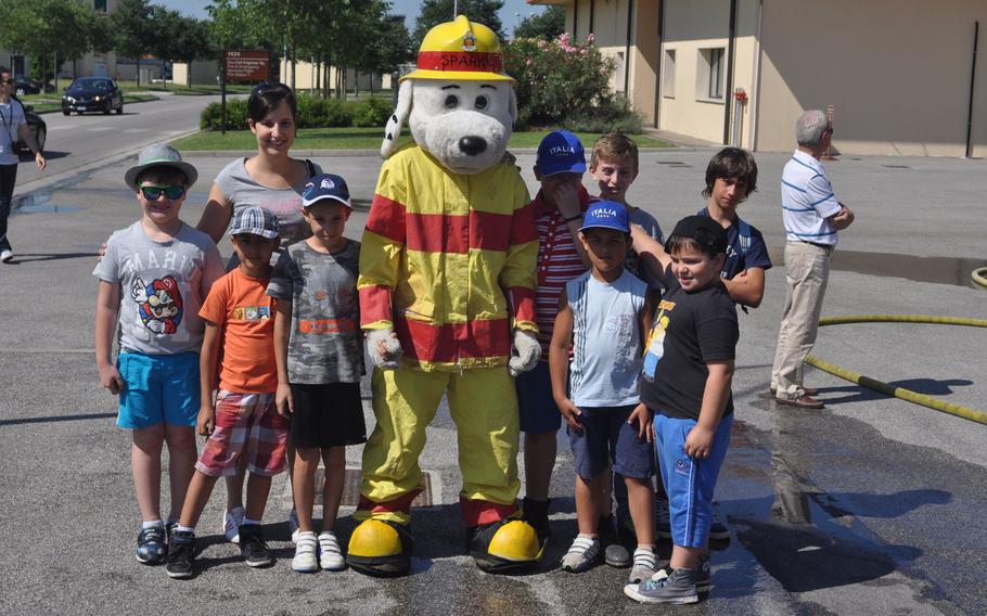 Sparky poses with a group of children touring Aviano Air Base, Italy on Friday, July 10, 2015.