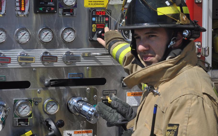 Senior Airman Gabrial Bazell adjusts the water pressure on a fire engine while visitors touring Aviano Air Base, Italy, fire water from the truck's hose Friday, July 10, 2015.