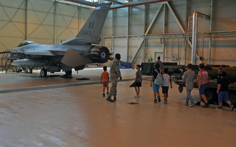 A group of visitors enters the hanger to view an F-16 Fighting Falcon provided by the 31st Fighter Wing's 510th Fighter Squadron, Friday, July 10, 2015, during a tour of Aviano Air Base, Italy.