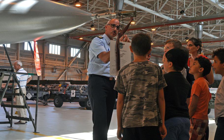 ITAF Technical Sergeant Zecca Stefano explains a few aspects of an F-16 Fighting Falcon on display Friday, July 10, 2015, at Aviano Air Base, Italy.