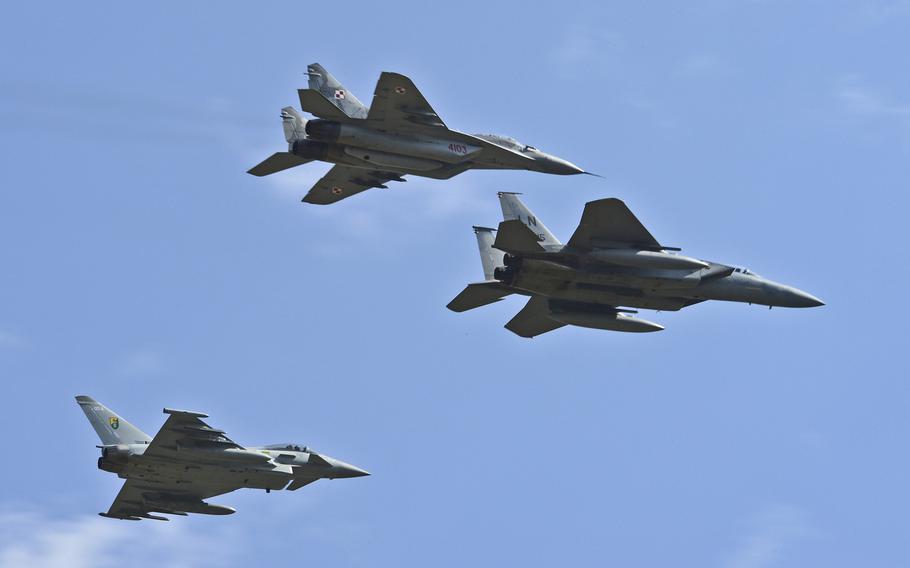 A Polish air force MiG-29, U.K. Royal Air Force Typhoon and a U.S. Air Force  F-15C Eagle fly in formation over Aiauliai Air Base, Lithuania, April 30, 2014. NATO will soon cut in half the number of fighters taking part in air policing missions over the Baltics from 16 to eight.
