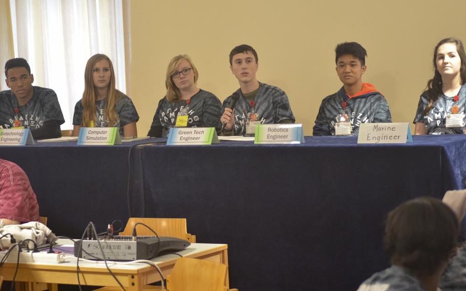 A team of students faces a simulated press conference during the DODDS-Europe STEMposium on Tuesday, Dec. 8, 2015. Teams were graded on their ability to explain their intentions and ideas to solve a real-world problem using engineering and innovation.