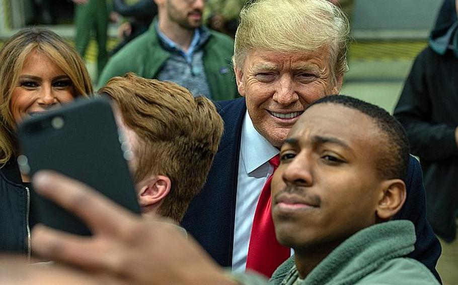 President Donald Trump and first lady Melania Trump pose for photos with troops at Ramstein Air Base, Germany, Thursday, Dec. 27, 2018.