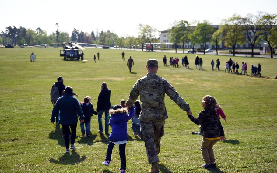 A soldier brings his kids to see a UH-60 Black Hawk helicopter during a Science Technology Engineering and Math activity on base, at Grafenwoehr, Germany, Tuesday, April 30, 2019.