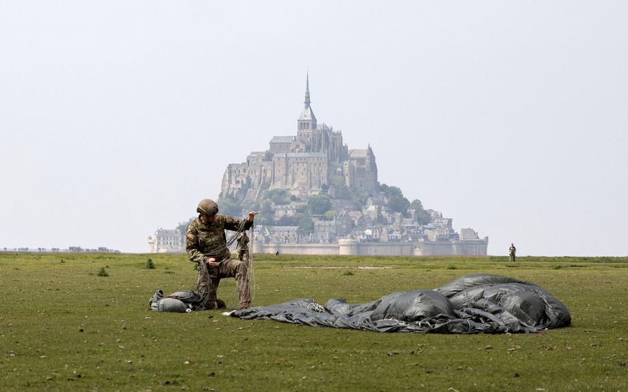 A paratrooper from the 10th Special Forces Group (Airborne) packs his parachute near the island of Mont Saint Michel, France, on Saturday, May 18, 2019. 