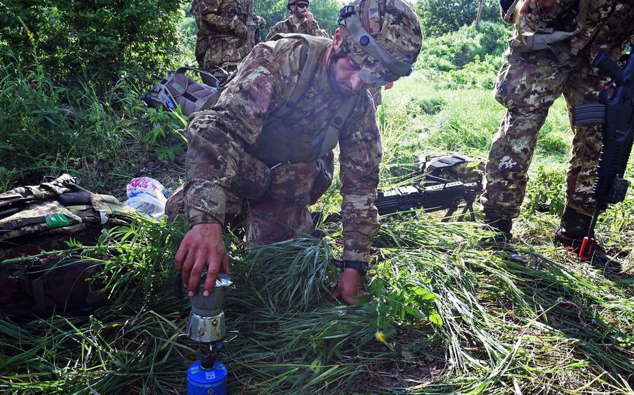 An Italian paratrooper sets up a portable espresso maker during Exercise Swift Response, in Bobocu, Romania, Friday, June 14, 2019.