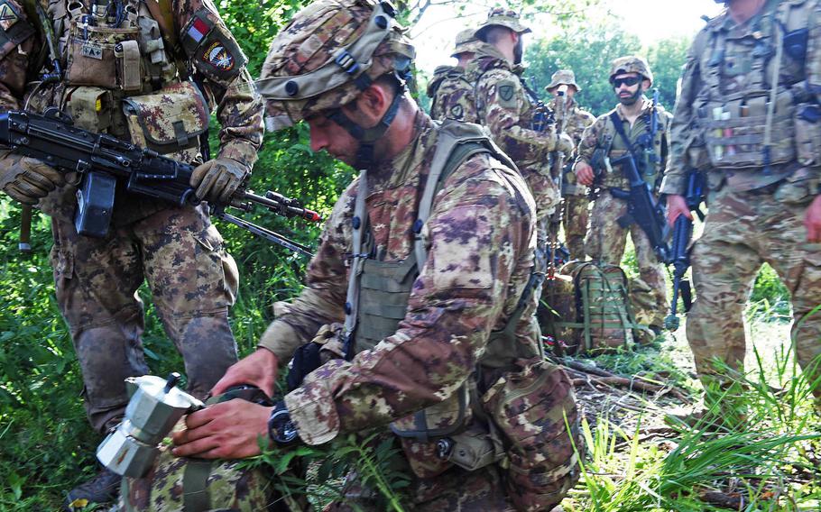 An Italian paratrooper gets out his gear, including a portable espresso maker, during Exercise Swift Response, in Bobocu, Romania, Friday, June 14, 2019.