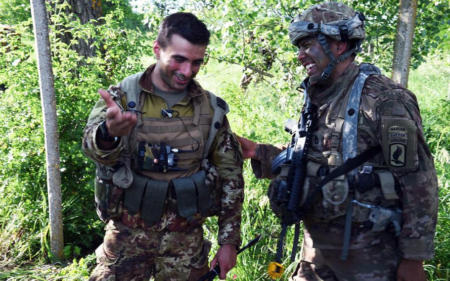 Capt. Valentino Luciano, the company commander of the Italian Folgore, left, and Sgt. 1st Class Felix Sanchez-Carrera, a paratrooper with the 173rd Infantry Brigade Combat Team (Airborne), share a laugh during Exercise Swift Respone, in Bobocu, Romania, Friday, June 14, 2019.