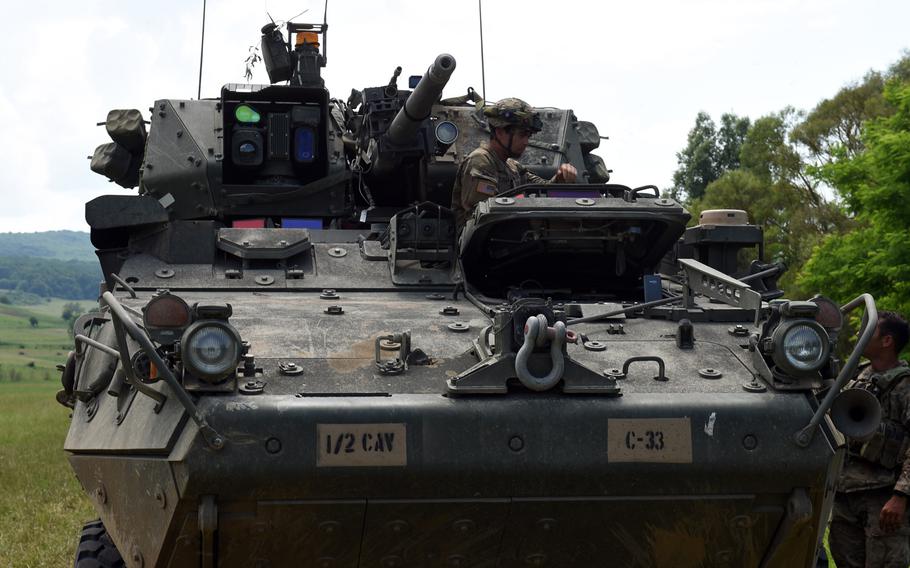 Soldiers with the Army's 2nd Cavalry Regiment talk before moving their Stryker vehicle into a defensive position, in Cincu, Romania, Monday, June 17, 2019.