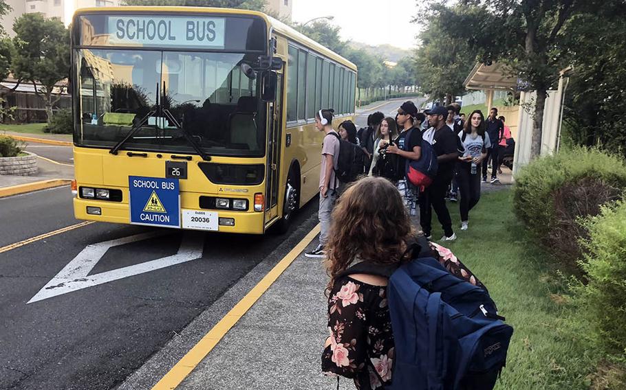 High school students wait for the school bus in the Ikego housing area near Yokosuka Naval Base, Japan, Monday, Aug. 27, 2018.