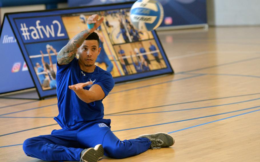 Jordan Lee-Fatt serves the ball during a seated volleyball match at the Warrior Care event at Ramstein Air Base, Germany. Lee-Fatt is currently on temporary disability retirement due to an autoimmune disease.  The event, which is part of the Air Force Wounded Warrior program, is the first of its kind at an Air Force base in Europe.