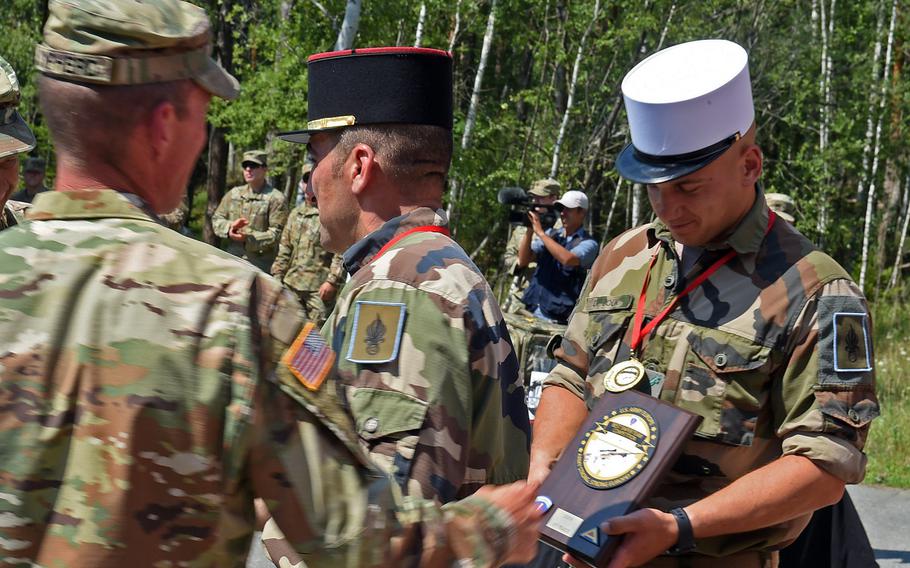 The French Foreign Legion sniper team accepts their plaque and awards from U.S. Army Sgt. 1st Class Jason Sypherd during the 2019 European Best Sniper Team Competition, at Grafenwoehr, Germany, Thursday, July 25, 2019.