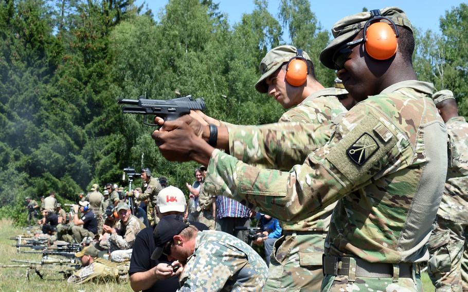 U.S. soldiers fire different handguns during the European Best Sniper Team Competition, at Grafenwoehr, Germany, Thursday, July 25, 2019.