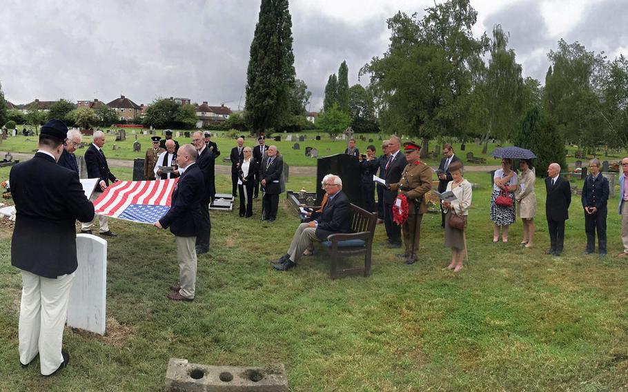 The U.S. flag is folded by members of a chapter of the Sons of Union Veterans of the Civil War in Hendon Cemetery, London, near the grave of Maj. Seth Herrick, who died in 1918. Herrick's great-grandson, Robert Herrick traveled from California to attend a ceremony on Saturday, July 27, 2019, to dedicate a headstone to Herrick, whose grave was found by British amateur historian Michael Hammerson, shown holding the lower right-hand corner of the flag. 