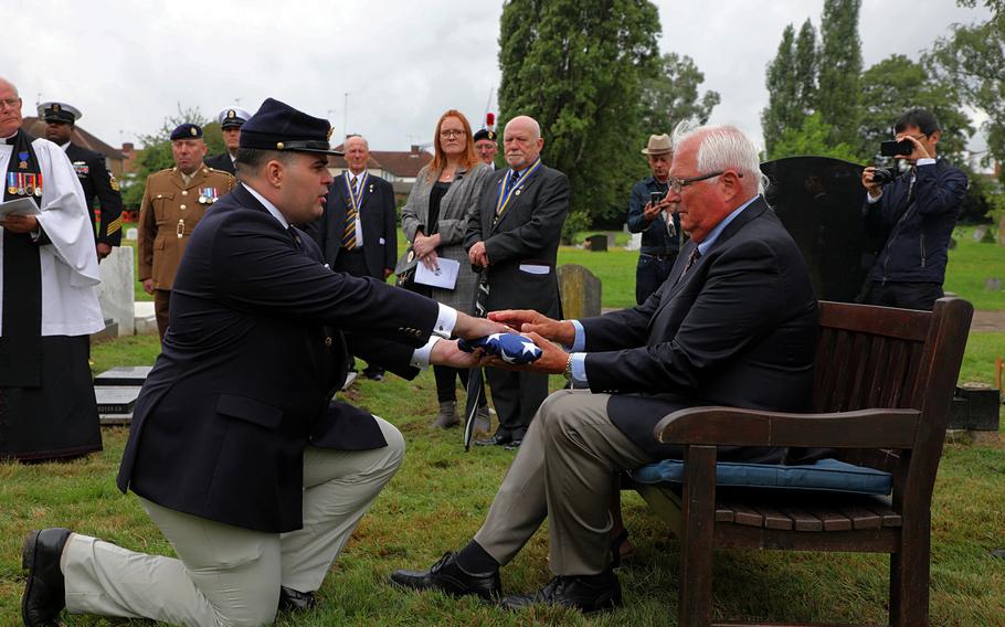 Matthew O'Neill, left, camp commander for Ensign John Davis Camp 10 Sons of Union Veterans of the Civil War, presents Robert Herrick, right, with a U.S. flag Saturday, July 27, 2019, during a ceremony to dedicate a gravestone to Herrick's great-grandfather, American Civil War veteran Maj. Seth Herrick, at Hendon Cemetery in north London.