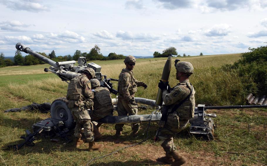 A soldier brings a 105mm artillery shell to an M119-A3 howitzer during an exercise in Grafenwoehr, Germany, Aug. 13, 2019.