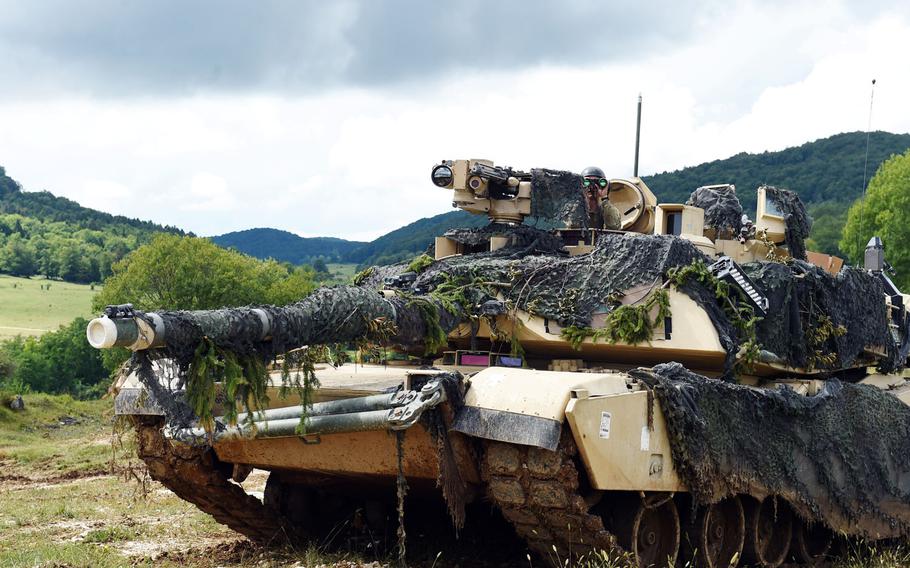 A soldier with 1st Infantry Division's 1st Armored Brigade Combat Team, scans the horizon from atop an M1A2 Abrams tank, during exercise Combined Resolve at Hohenfels, Germany, Monday, Aug. 19, 2019.