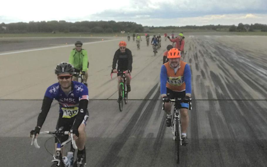 Cyclists ride down the flight line on RAF Lakenheath during a 24-hour endurance ride to raise awareness about suicide, on  Saturday June 16, 2019.