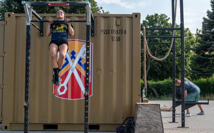 Sgt. Lauren Meza does pullups while Maj.Joshua Rookus lifts weights on a military base in Powidz, Poland, Aug. 27, 2019. The soldiers deployed to the base are on rotations lasting up to nine months.