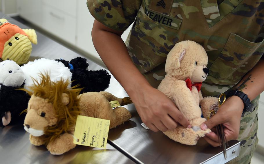 A stuffed bear's wound is displayed on the operating table at the teddy bear suture clinic in Vilseck, Germany, Wednesday, Aug. 28, 2019. Army veterinary technicians at the clinic practiced stitching up wounds on all types of stuffed animals, not just teddy bears.