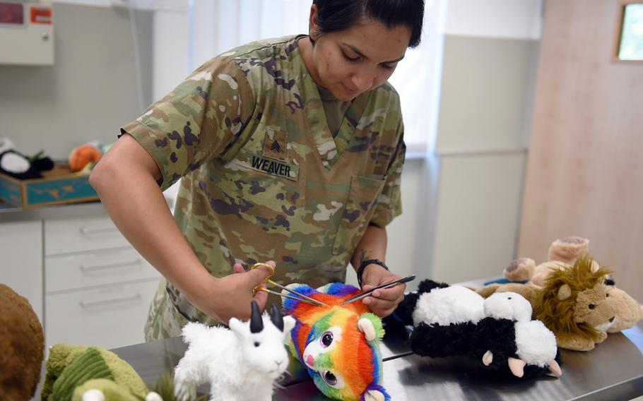 Sgt. Toni Weaver, an animal care technician at Rose Barracks, operates on her patient, "Rainbow Kitty," at a clinic for stuffed animals in Vilseck, Germany, Wednesday, Aug. 28, 2019.