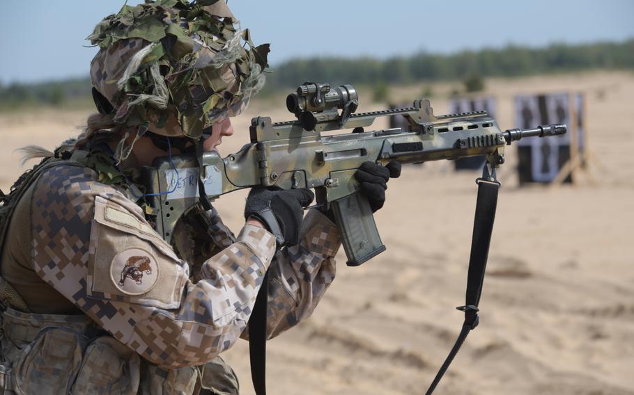 A Latvian soldier fires her rifle from the standing position during the ?live-fire? event of the Best Infantry Squad Competition, Aug. 28, 2019, in Rukla, Lithuania.