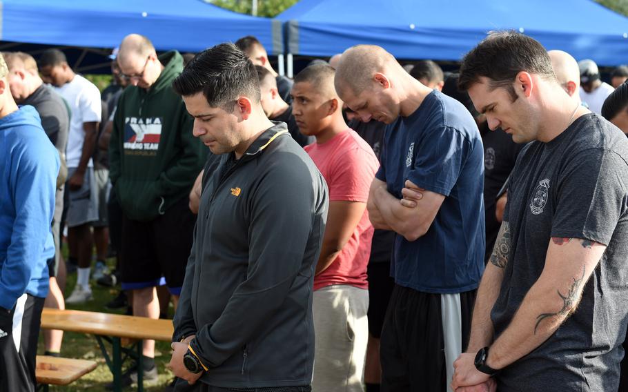 Soldiers, veterans and families lower their heads as a chaplain says a prayer before the Windy 25 5K run at Ansbach, Germany, Sept. 6, 2019. The race memorializes those who died in the Windy 25 helicopter crash in Afghanistan in 2005 and raises money for families who have lost loved ones in the military.