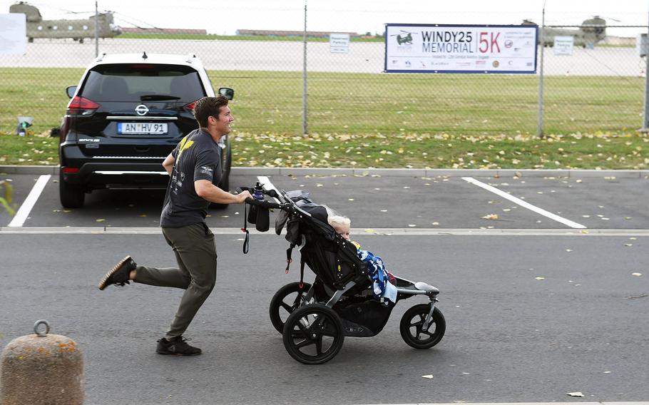 Capt. Cody Omilusik, the commander of "Big Windy," runs with a baby in a jogging stroller during the Windy 25 5K memorial run at Ansbach, Germany, Sept. 6, 2019.  