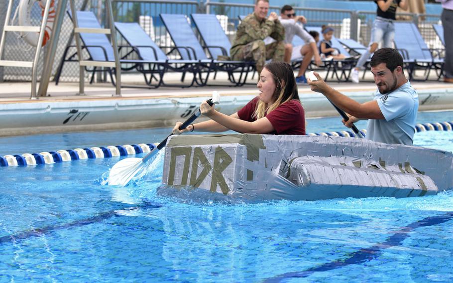 Savannah Inman and Brandon Garneau with the 31st Fighter Wing's outdoor recreation department at Aviano Air Base, Italy, on their way to winning the first cardboard boat race to be held at the base on Sept. 19, 2019.