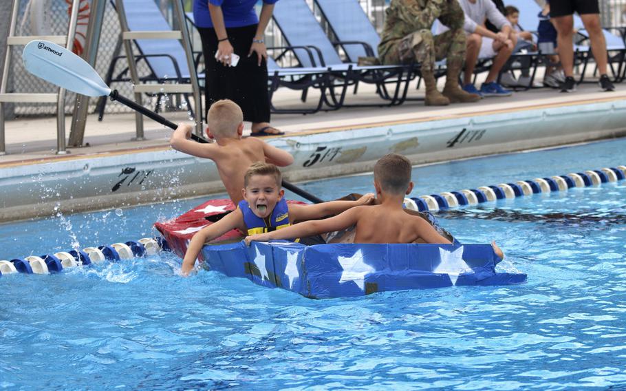 Five-year-old Zachary Odom, center, his brother Asher, 8, left, and a friend compete in the first cardboard boat race to be held at Aviano Air Base in Italy on Sept. 19, 2019. The boys received a trophy for having the most creative boat.