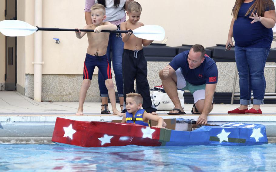 Zachary Odom, 5, takes a seat inside a cardboard boat at the cardboard boat race, held at Aviano Air Base in Italy, Sept. 19, 2019.