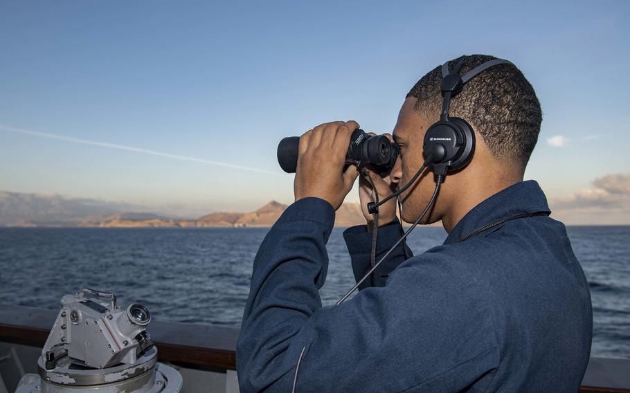 Seaman Recruit Bryan Rosado stands the starboard bridge wing lookout watch as the guided-missile cruiser USS Normandy approaches Souda Bay, Greece for a scheduled port visit Oct. 6, 2019.