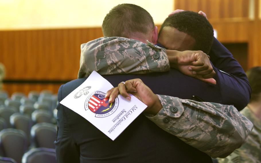 Senior Airman Walter Boze, holding program, embraces Tech. Sgt. Robert Davis after the memorial service on Tuesday, Oct. 22, 2019, for Airmen 1st Class Jacob A. Blackburn and Bradley Reese Haile at Spangdahlem Air Base, Germany. Blackburn and Haile were killed last month in car crash on base.