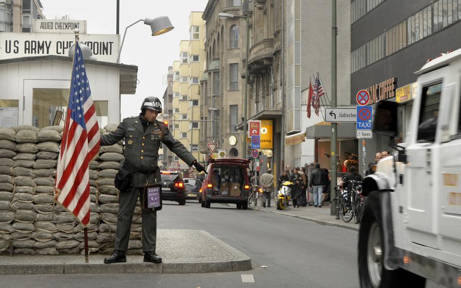 A man dressed as a U.S. soldier stops a vehicle at the original site of the famous Checkpoint Charlie in Berlin. Berlin authorities are banning a group of actors from posing as US army soldiers at the  replica of the original checkpoint on Friedrichstrasse, following reports that they harass tourists.