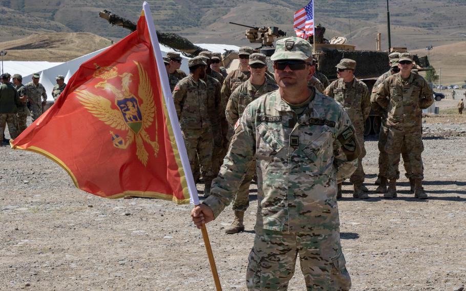 A soldier holds a Montenegrin flag during the closing ceremony of the multinational Agile Spirit 19 exercise at Orpholo Training Area, Georgia, in August 2019. NATO is deploying a team specialized in countering hybrid warfare threats to Montenegro, its newest member state, ahead of elections in the Balkan state next year.