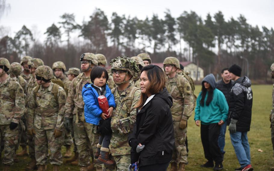 First Sgt. Brian Lomibao, center, holds his son Eliot, who's clutching the goodie bag the family got for taking part in a 3-mile march on Grafenwoehr Training Area in Germany, as part of a holiday toy collection for needy children.