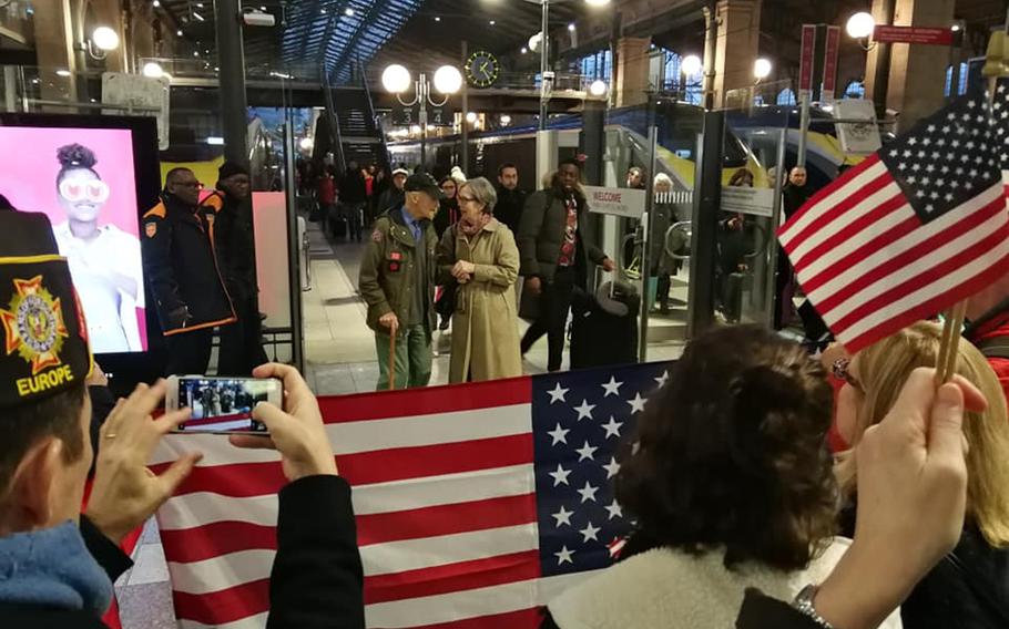 Stephen Weiss, an American World War II veteran who worked with the Office of Strategic Services behind enemy lines in France in 1944, is greeted by Meredith Wheeler, an American expatriate living in southern France, and other American well-wishers at Paris's Gare du Nord train station on Thursday, Feb. 13, 2020.